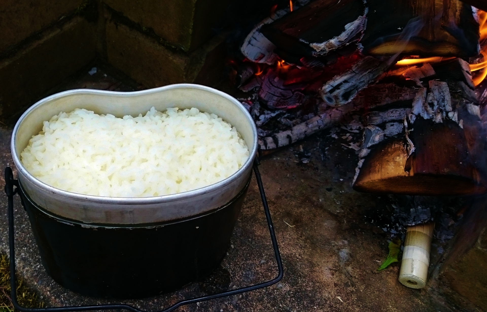 飯盒に入ったお米と、焚き火の画像