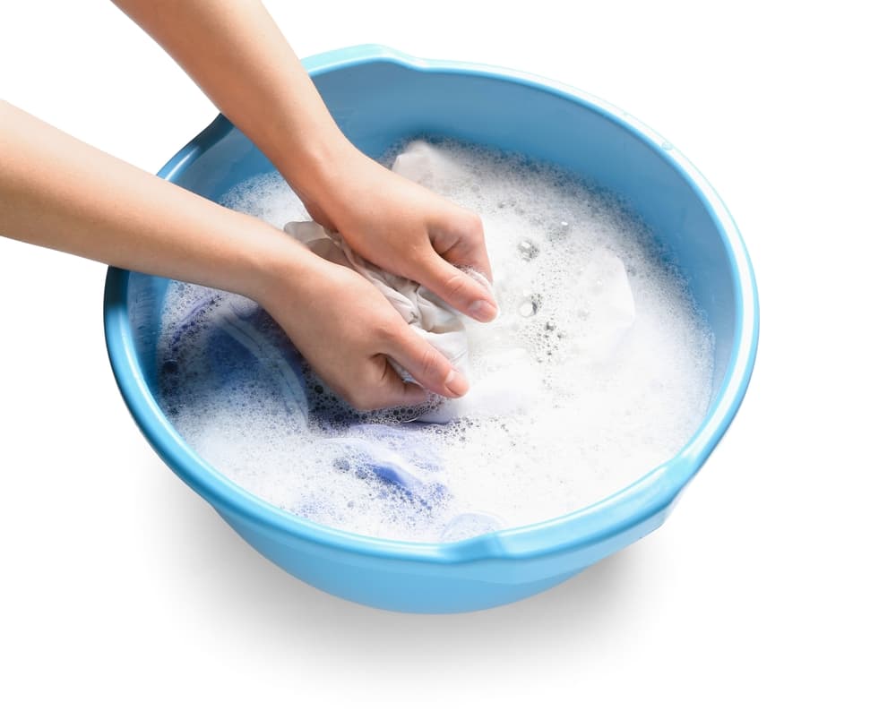 桶の中で、洗剤を使って洗濯をしている画像