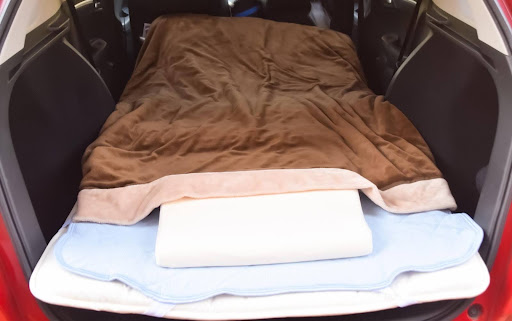 毛布や枕などの寝具がセットされている車内