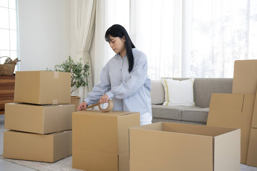 引越し作業で段ボール箱をガムテープで補強中