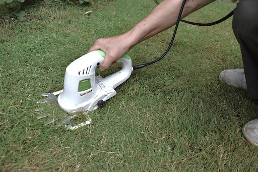 “芝生用バリカンで芝刈りしている様子"
