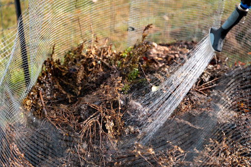“コンポストに水を入れて基材の水分量を調整してている様子"