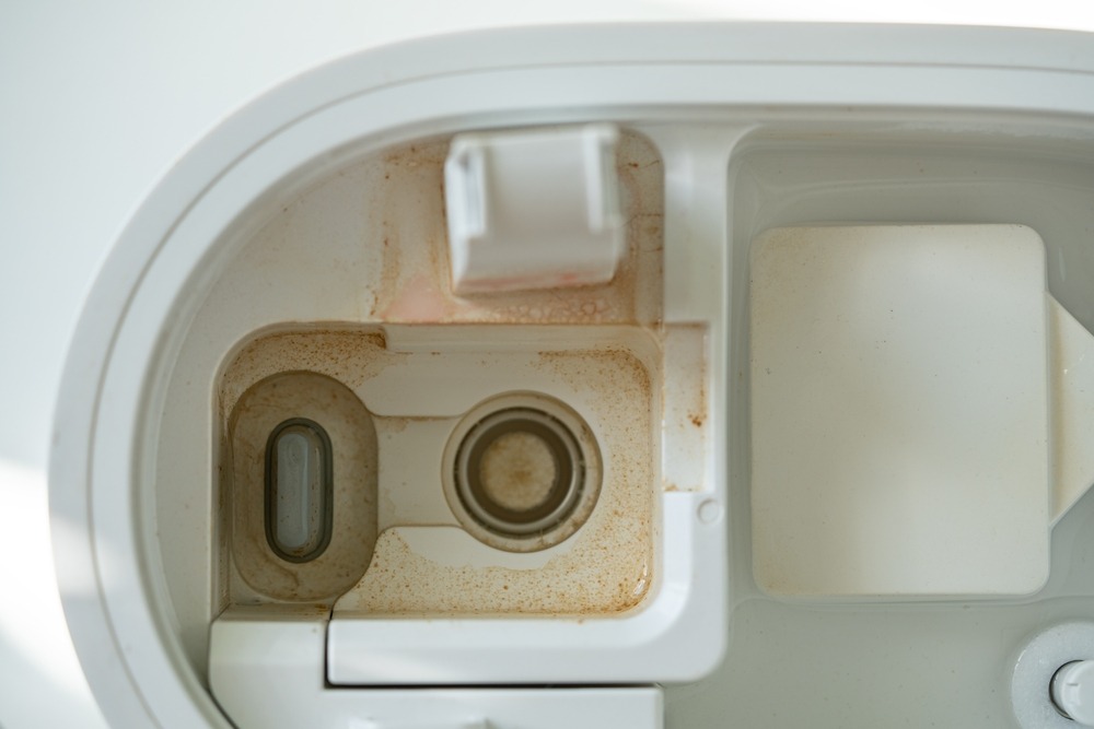 茶色い水垢とぬめりが付着した加湿器のトレイ内部