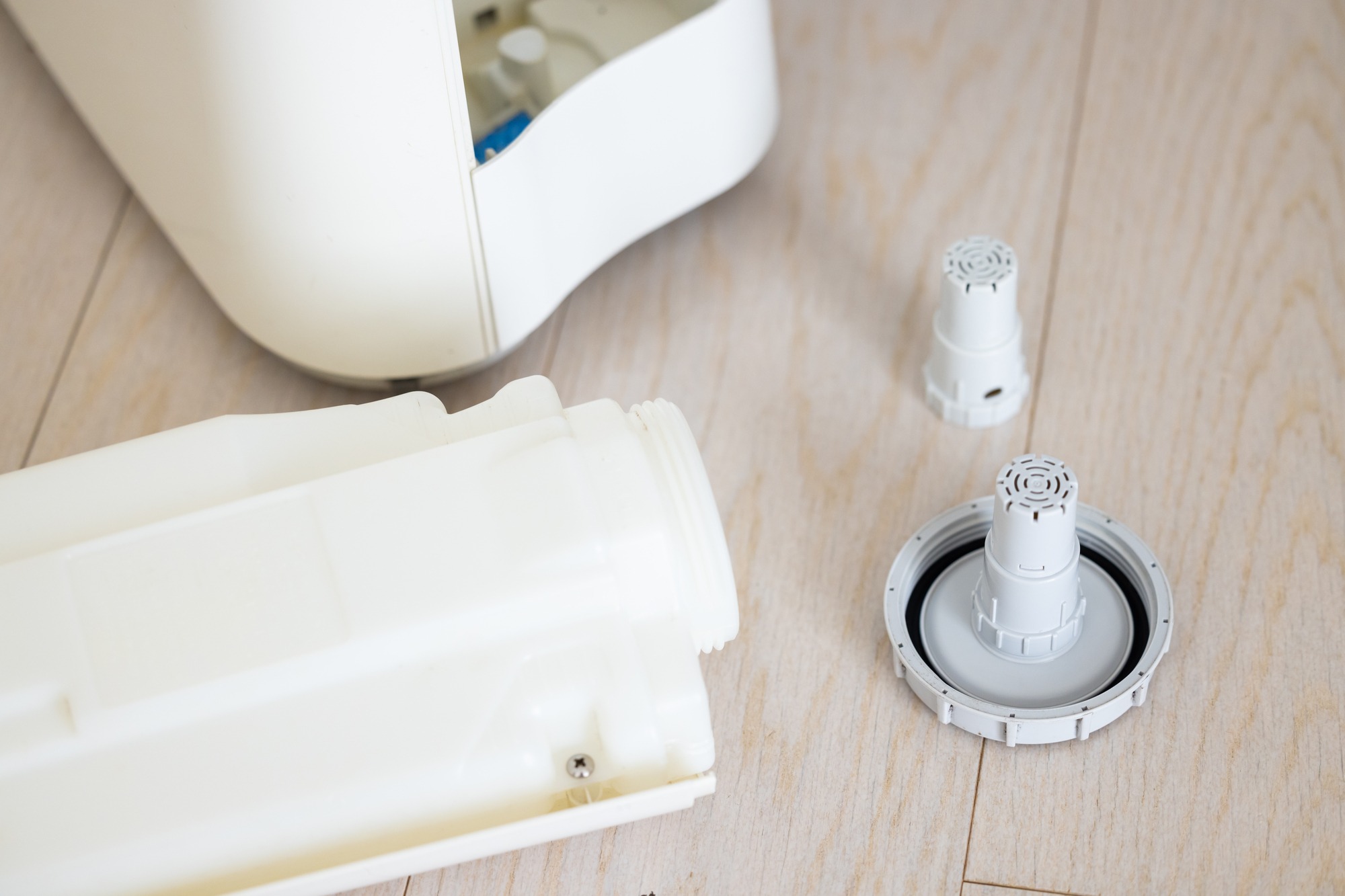 床に並べて分解された加湿器のタンクとフィルター部品