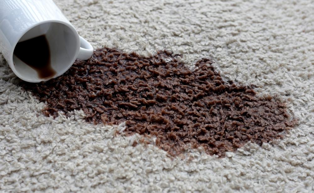 カーペットにこぼれたコーヒーと倒れたカップ