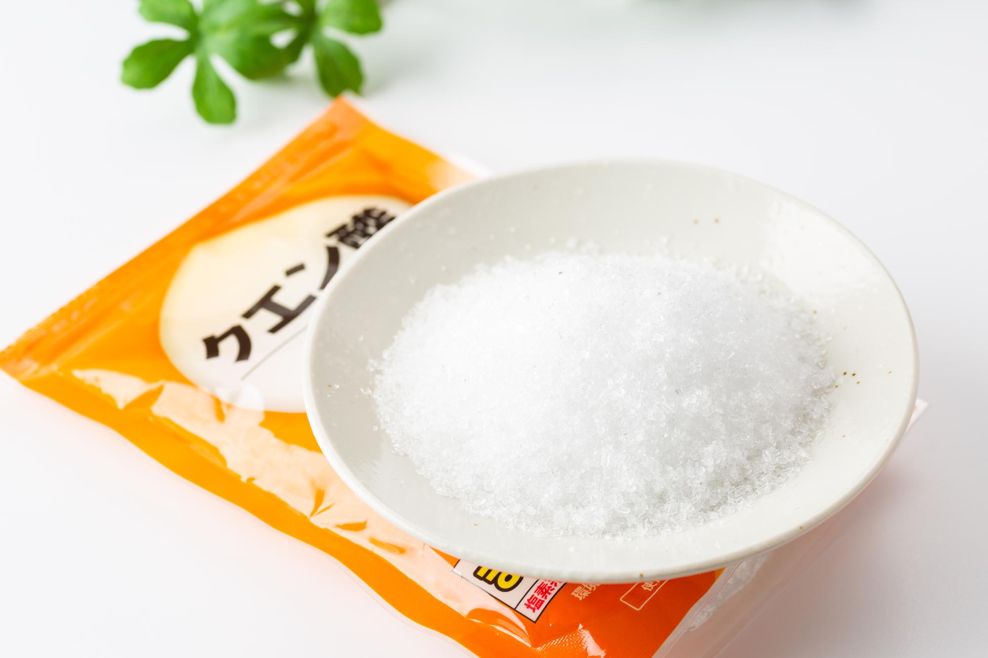 クエン酸の袋とスプーンに盛られた白い粉末