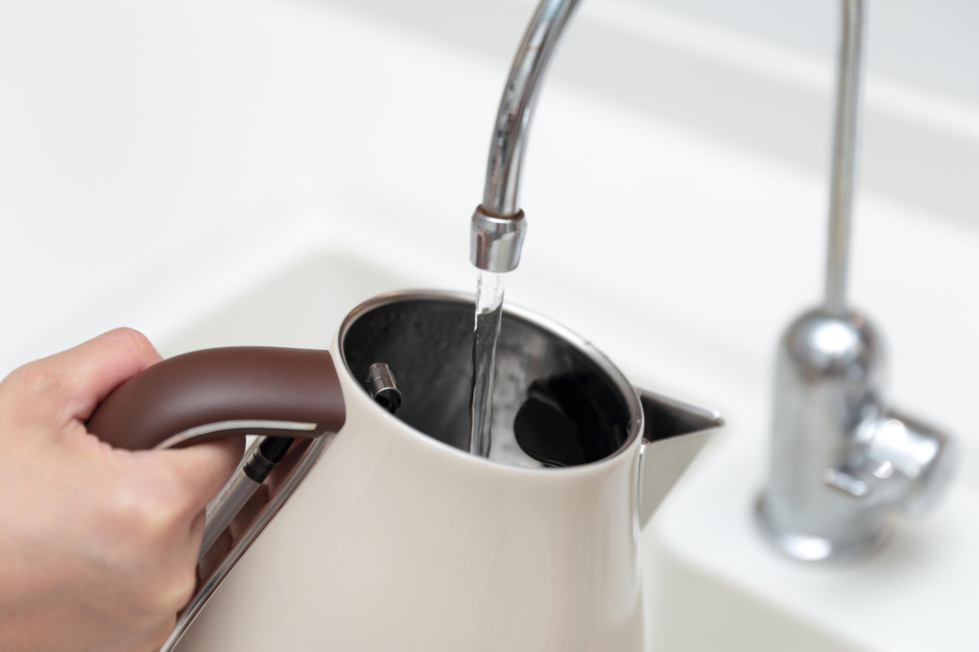蛇口から電気ケトルに水を入れる様子